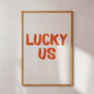 Framed artwork with 'LUCKY US' text on a white wall
