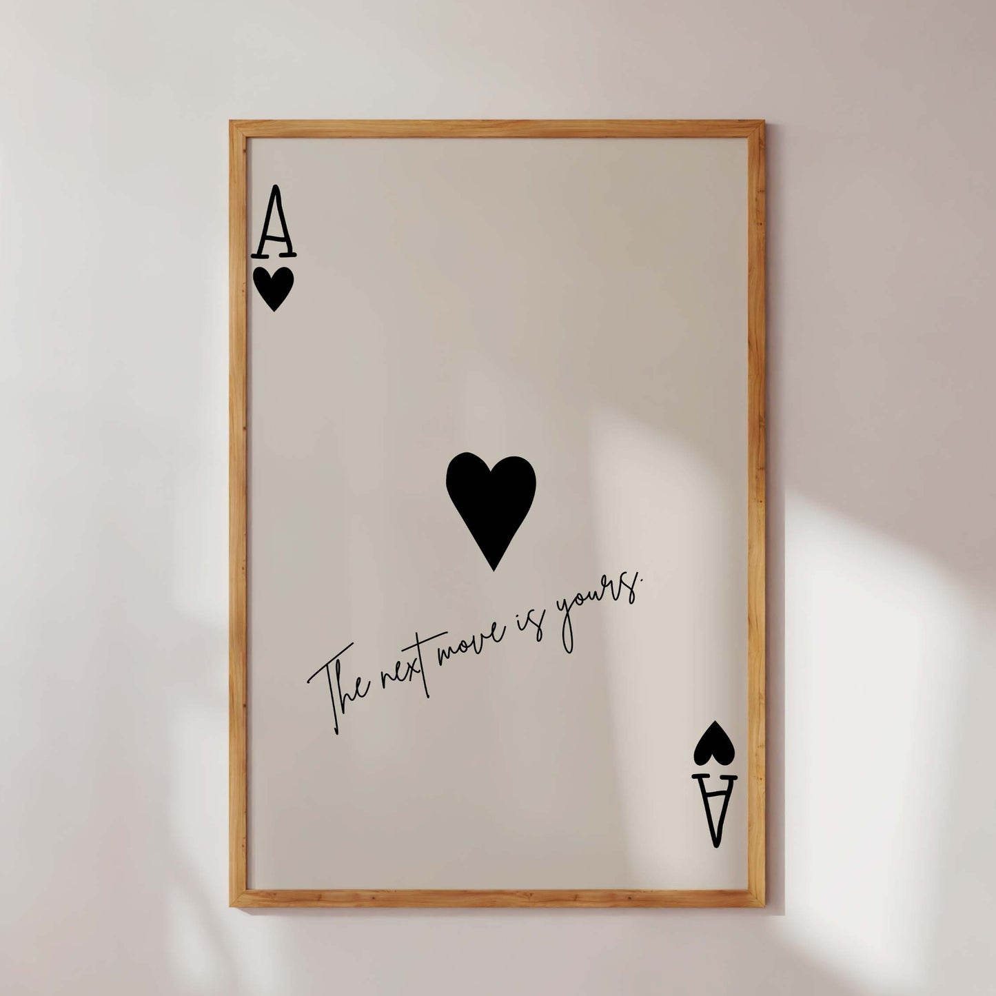 Framed artwork with playing card symbols and text on a white wall