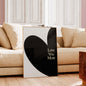 Heart-shaped artwork with 'Love You More' text in a living room setting.