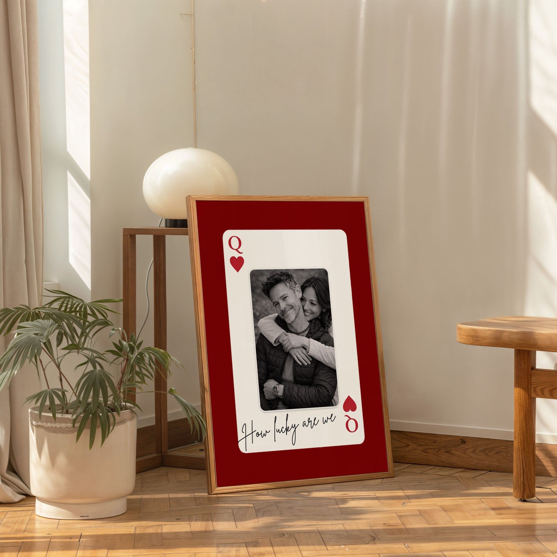 Large personalized playing card wall art in modern living room with chair and decor